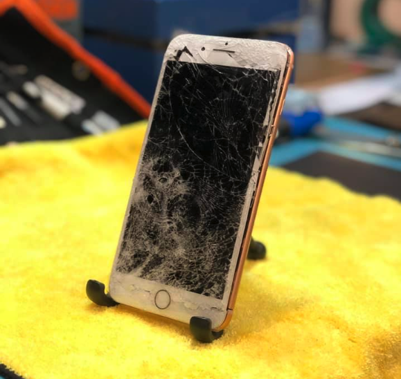 iPhone with glass shattered waiting to be repaired.